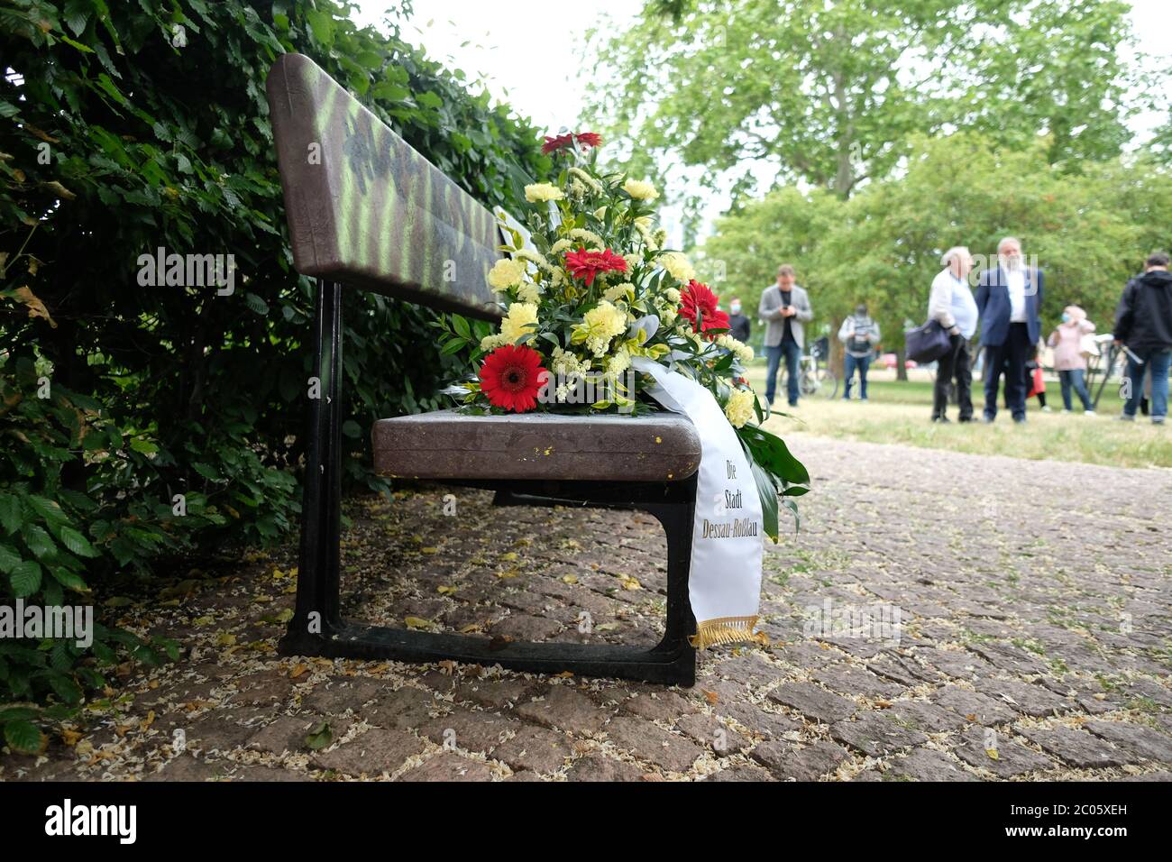 11 giugno 2020, Sassonia-Anhalt, Dessau-Roßlau: I fiori sono stesi su una panchina alla stazione ferroviaria di Dessau. Lì, il 1 agosto 2008, il mentalmente danneggiato Hans-Joachim Sbrzesny è stato assassinato da due neo-nazisti. Un ricordo silenzioso è stato fatto di questo. Foto: Sebastian Willnow/dpa-Zentralbild/dpa Foto Stock