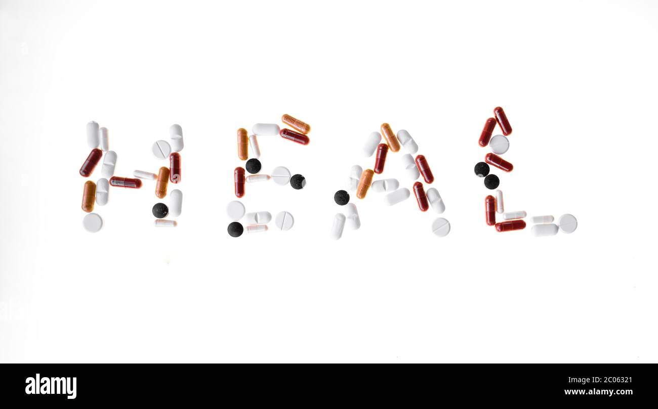 Pillole colorate, compresse formano la parola guarire, guarigione, simbolica immagine malattia, sfondo bianco, Germania, Germania Foto Stock
