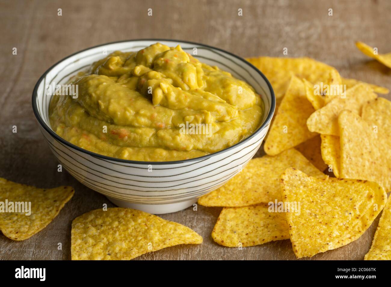 Guacamole e tortilla fresche fatte in casa ad un tavolo di legno Foto Stock