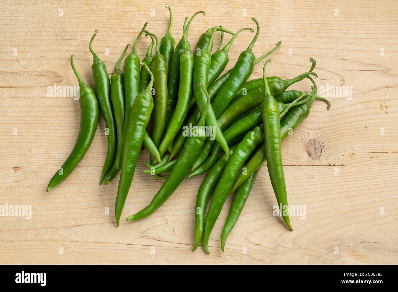 Gruppo di peperoncini verdi freschi su tavolo di legno Foto Stock