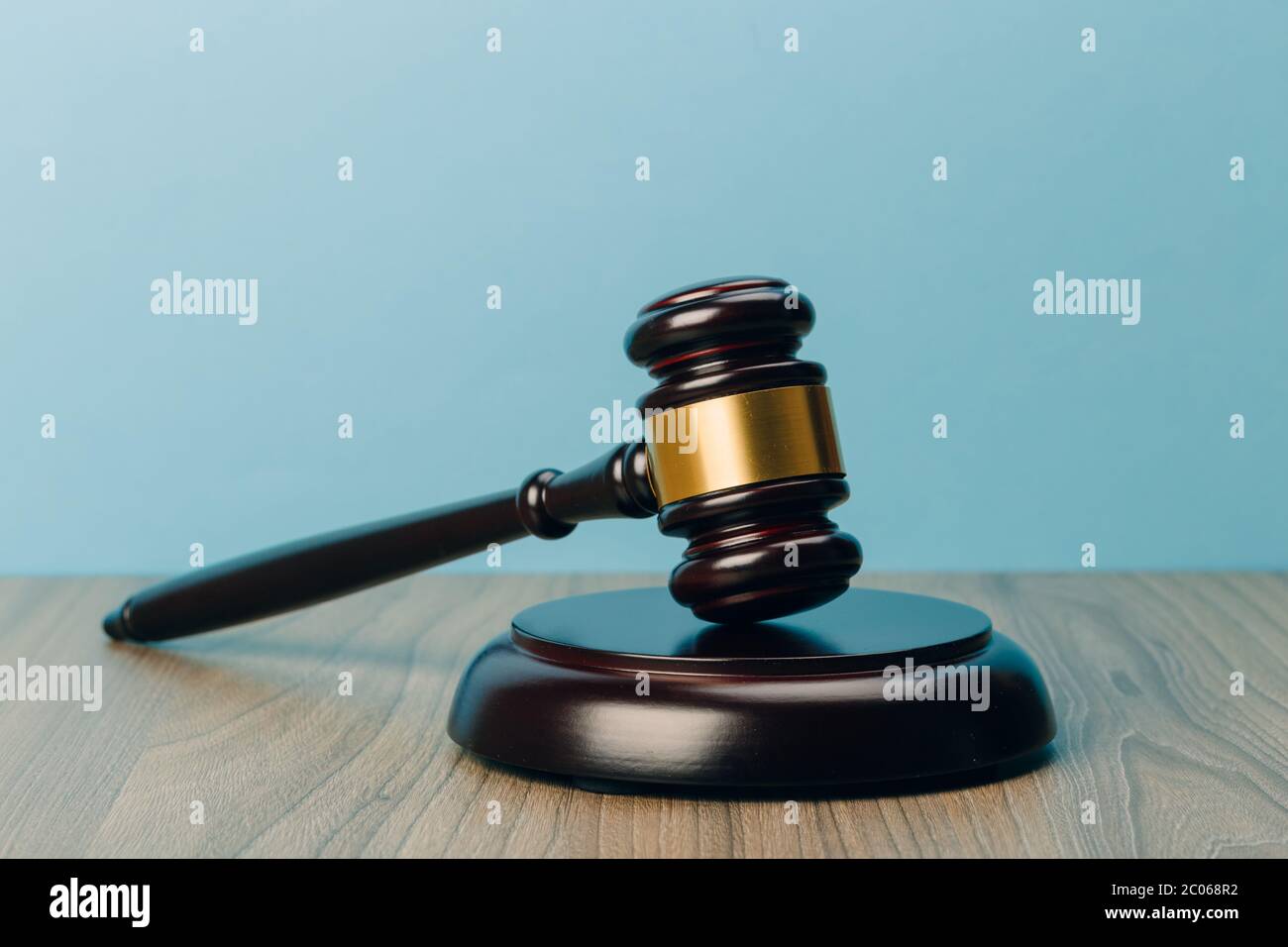 Simbolo di legge e giustizia su un tavolo di legno e sfondo blu nell'ufficio legale Foto Stock