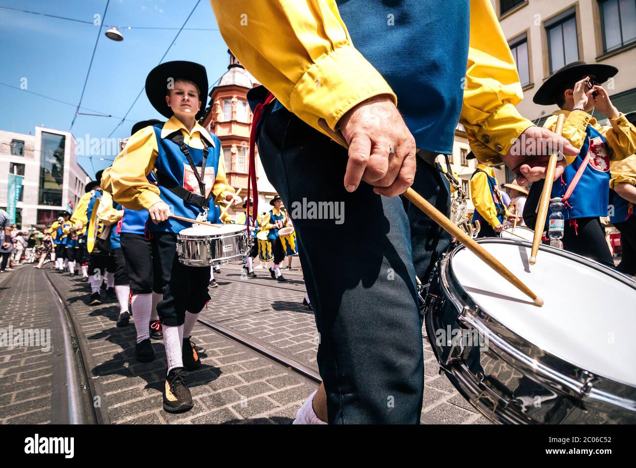 Primo piano di mani batteriste, musicisti del gruppo musicale TSG del villaggio Estenfeld in costume folk tipico alla sfilata di apertura della fiera estiva Kiliani. Foto Stock