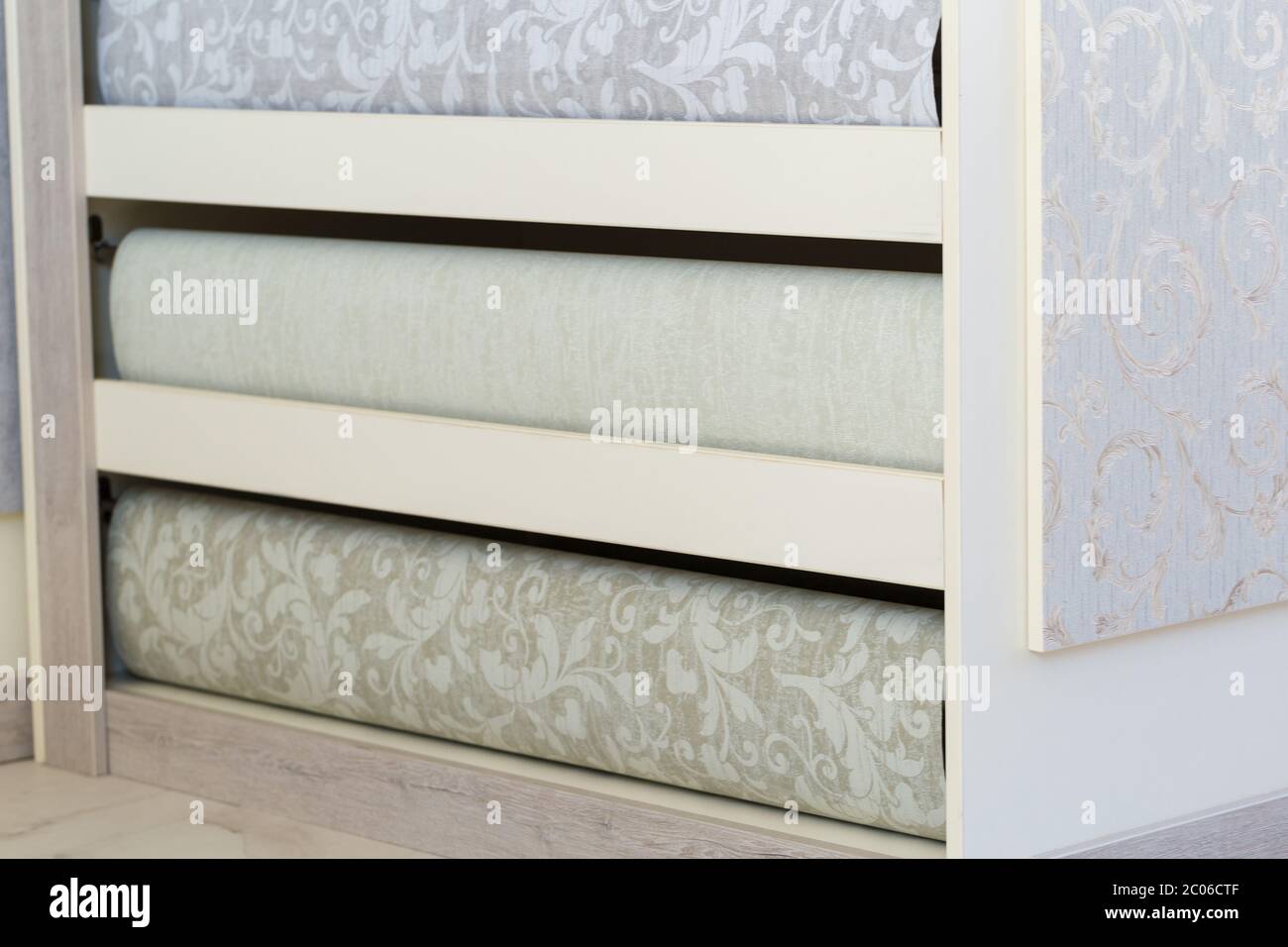 Scaffalatura nel negozio. Elegante multicolore con rotoli dal design moderno. Sfondi di lusso per interni. Foto Stock