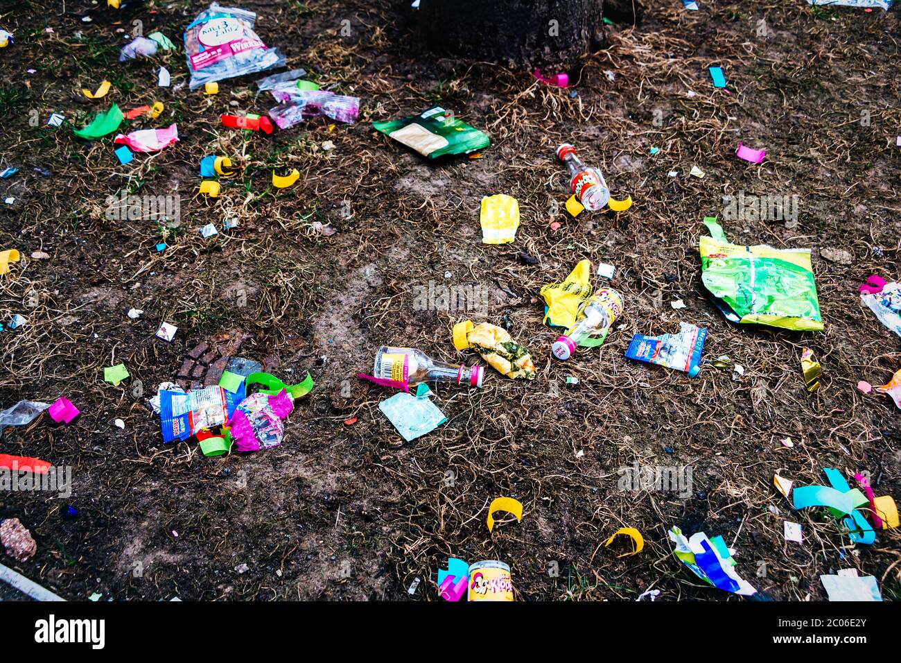 Gli imballaggi di cioccolato vuoti, le decorazioni del festival e altri rifiuti di plastica colorati sono sdraiati sulla strada dopo la tradizionale grande sfilata di carnevale Foto Stock