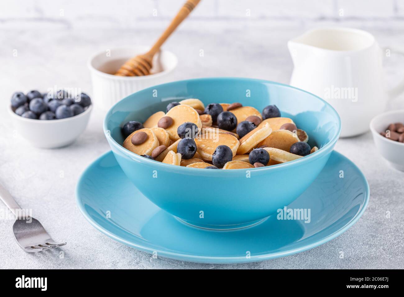 Colazione alla moda con mini pancake, mirtilli e patatine al cioccolato, focalizzazione selettiva. Foto Stock