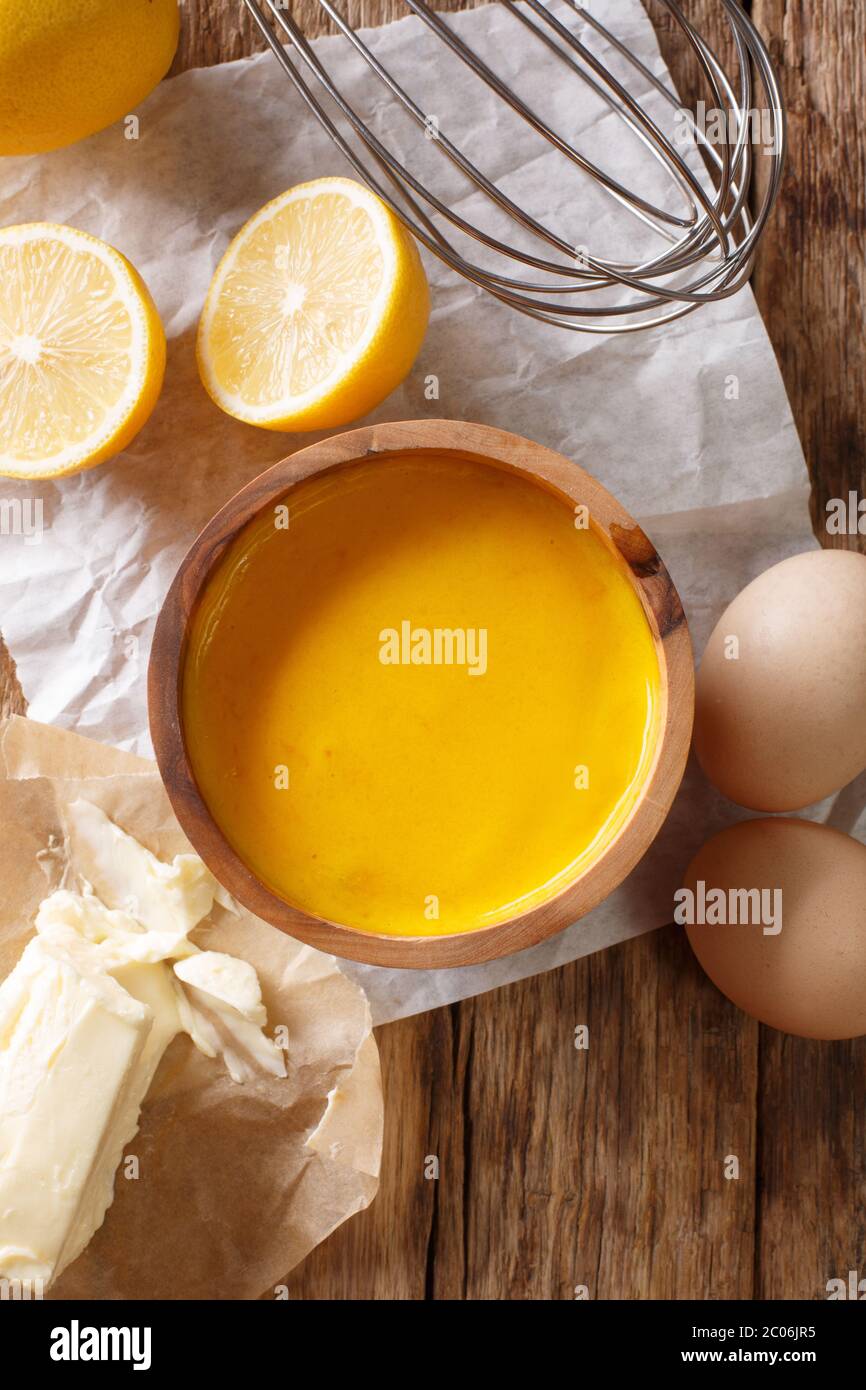 Salsa di hollandaise preparata al momento con ingredienti da vicino sul tavolo. Vista dall'alto verticale Foto Stock