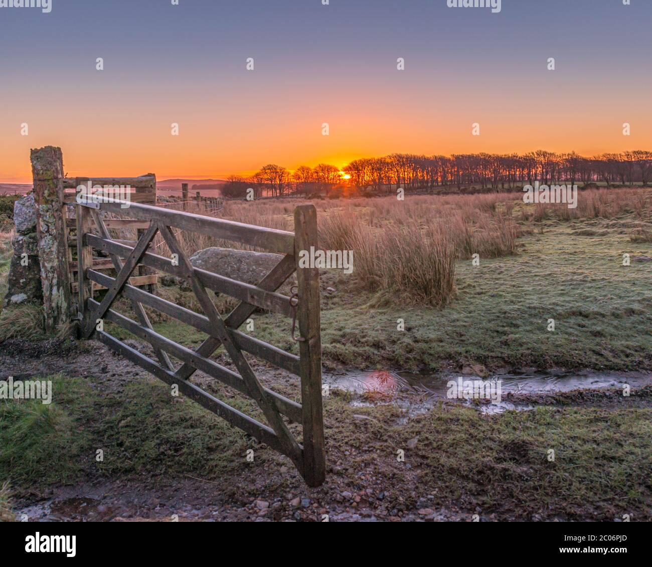 Gelido gateway invernale mattutino su Dartmoor con il sole che si alza alle spalle. Foto Stock