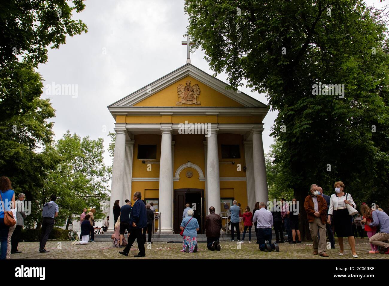 Devoti visti fuori dalla parrocchia della Beata Vergine Maria di Czestochowa, in via Kochanowskiego, durante l'evento. Festa del corpo e del sangue di Cristo (Corpus Christi) È una festa dedicata alla venerazione del corpo e del sangue di Cristo, in cui il pane e il vino si trasformano durante l'Eucaristia secondo la fede cristiana. Secondo la tradizione, in questo giorno si organizza una solenne processione per le strade della Chiesa cattolica. In Polonia, questo giorno è una festa pubblica. Quest'anno, molti partecipanti alla processione indossavano maschere mediche, tra cui server di altare e monache. Foto Stock