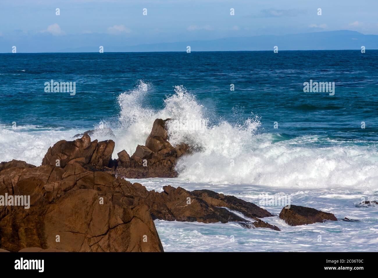 L'onda dell'oceano si sprigiona contro le grandi rocce sulla riva di Monterey Bay, California Foto Stock