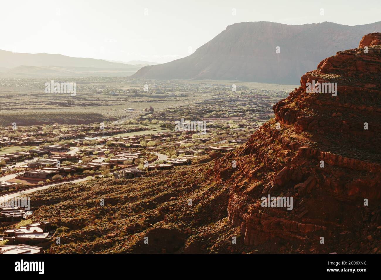Le scogliere rosse si innalzano sopra lo sviluppo suburbano sul bordo di St. George Utah Foto Stock