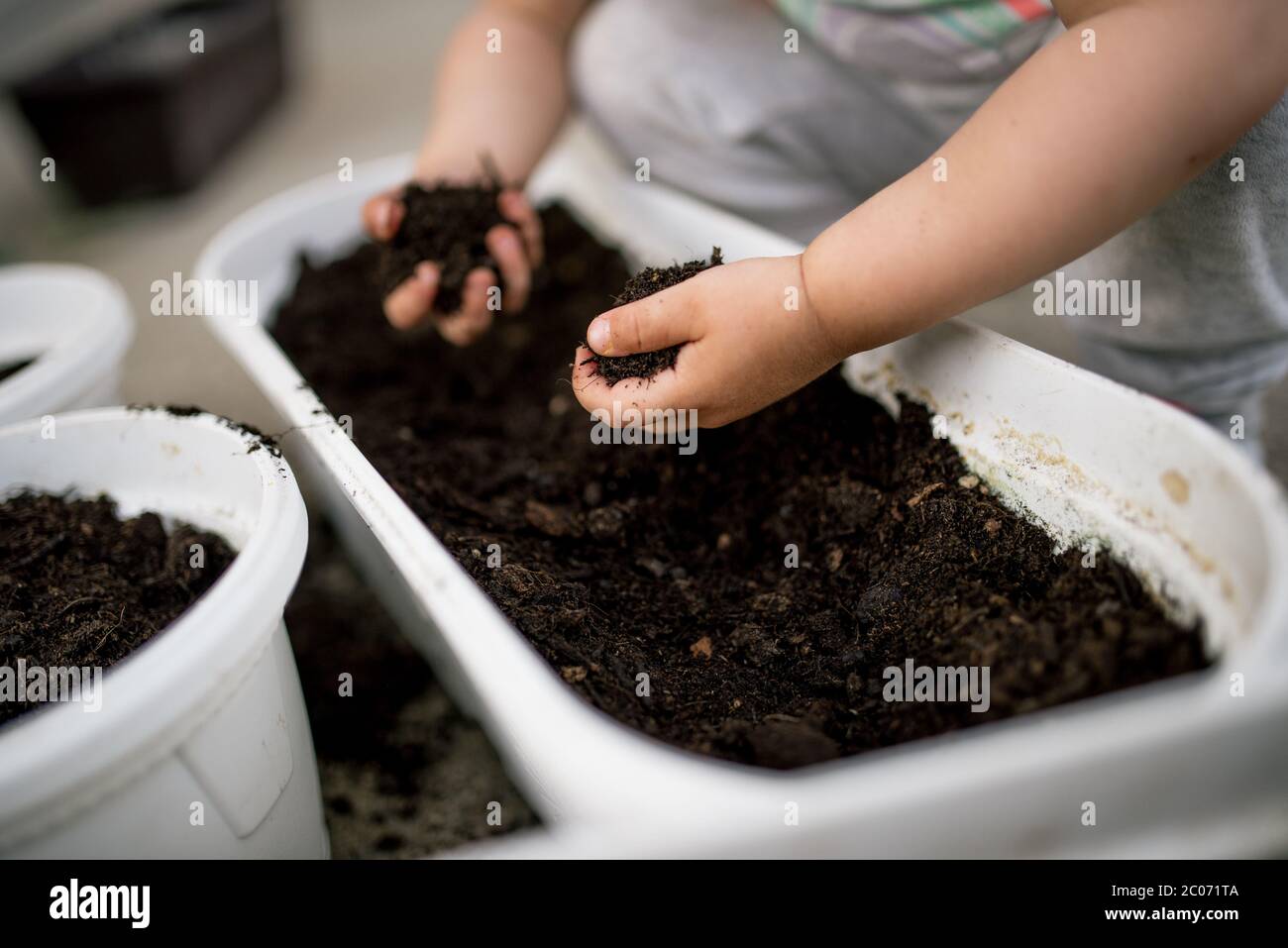 Una bambina si diverte in giardino e tiene un terreno da giardino Foto Stock