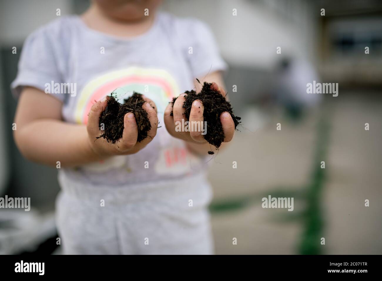 Una bambina tiene un giardino trama Foto Stock