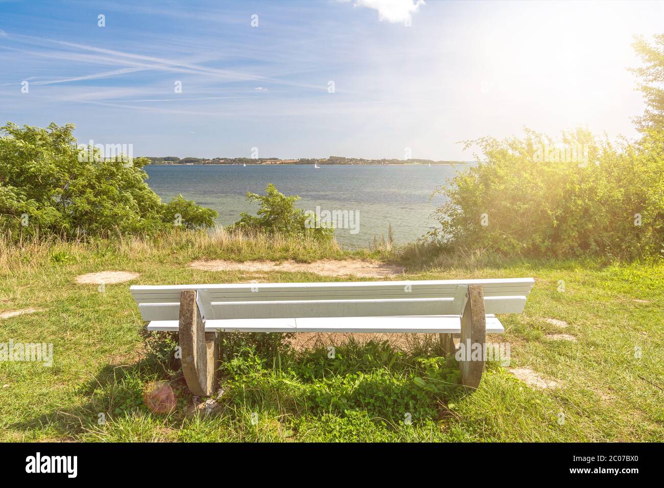 Panchina solitaria in una giornata di sole di fronte al bellissimo Mar Baltico nel nord della Germania Foto Stock