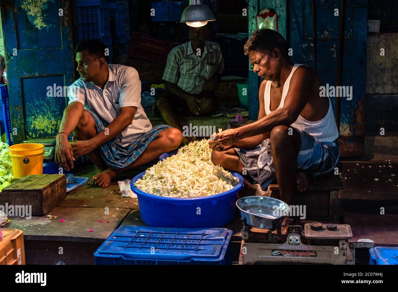 Chennai, Tamil Nadu, India - Agosto 2018: Un anziano indiano che lavora all'interno del suo negozio al mercato dei fiori di Georgetown. Foto Stock