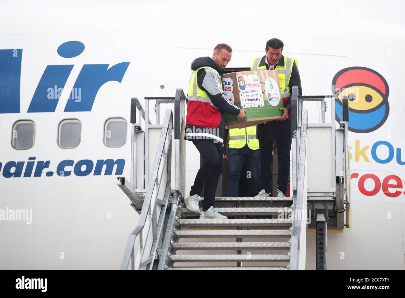 Calum Best (a sinistra) e Tamer Hassan aiutano a scaricare scatole di dispositivi di protezione personale (PPE) da un aereo all'aeroporto Robin Hood di Doncaster, nello Yorkshire del Sud. ??30,000 il valore di PPE è stato donato alla carità Mask Our Heroes, che è stata istituita dall'attore Tamer Hassan sulla scia dell'epidemia di coronavirus per aiutare a fornire i dispositivi di protezione di cui hanno bisogno ai lavoratori della prima linea NHS e della salute. Foto Stock