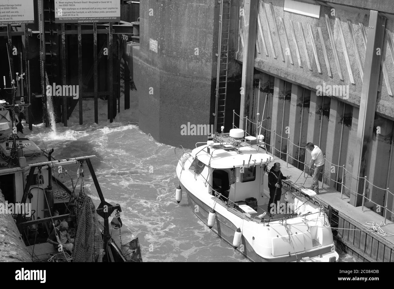 I pescatori di pescherecci da traino attraversano le porte di chiusura della baia di Cardiff Barrage con le loro catture a bordo. La bassa marea mostra l'altezza delle strutture Foto Stock