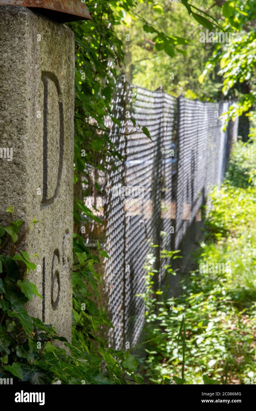 Wegen der Ausbreitung des Corona-Virus haben die Schweiz und Deutschland ihre Grenzen geschlossen. Alter Hintergarten-Grenzaun mit Grenzstein D16C. K Foto Stock