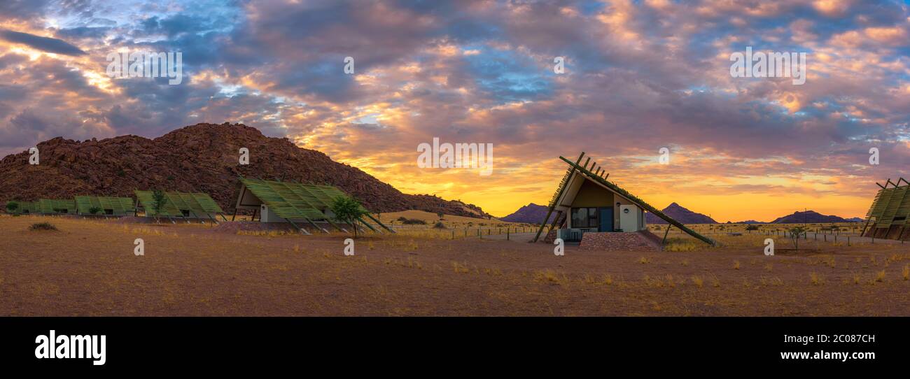 Sunrise sopra i piccoli chalets di una desert lodge vicino al Sossusvlei in Namibia Foto Stock