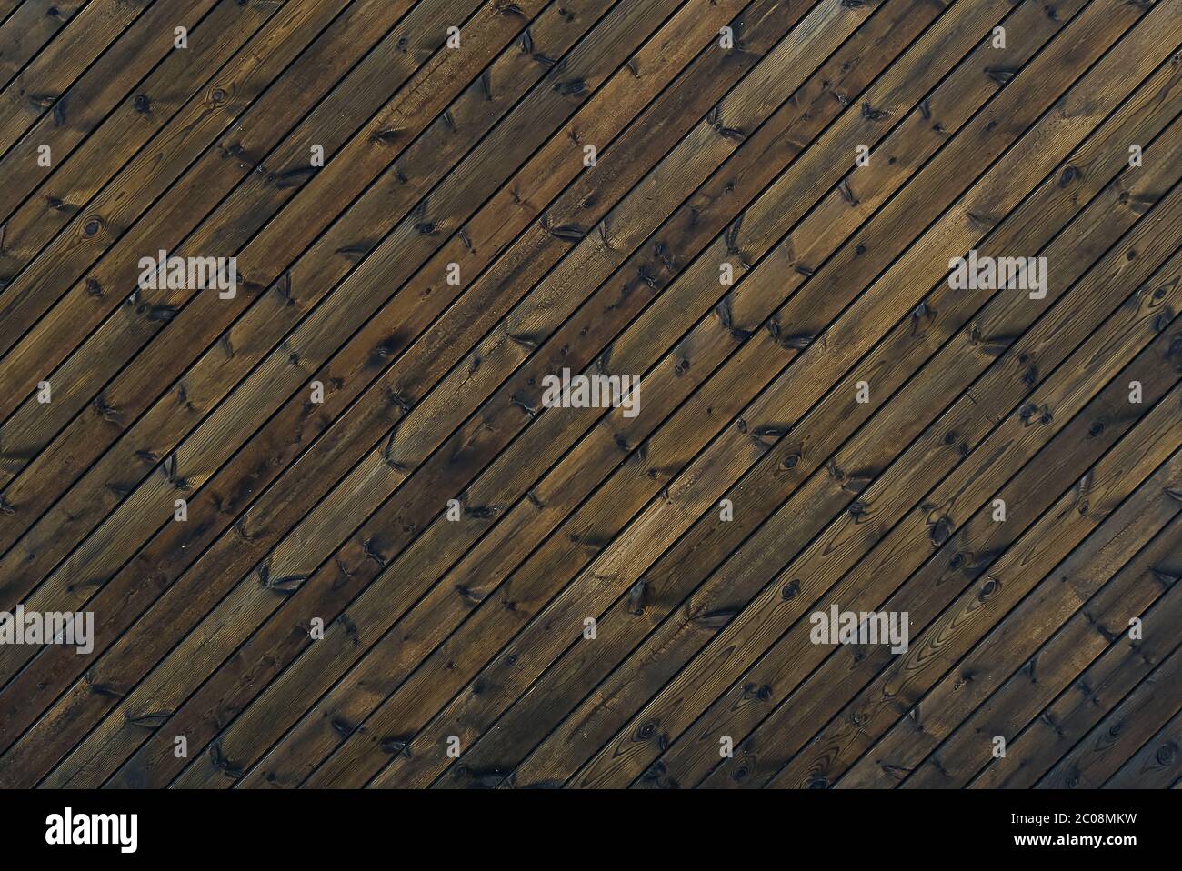 Legno struttura sfondo marrone scuro colore 45 gradi. Struttura di vecchie tavole di legno ad un angolo obliquo. Diagonale sfondo marrone tavole di legno vecchio. Foto Stock