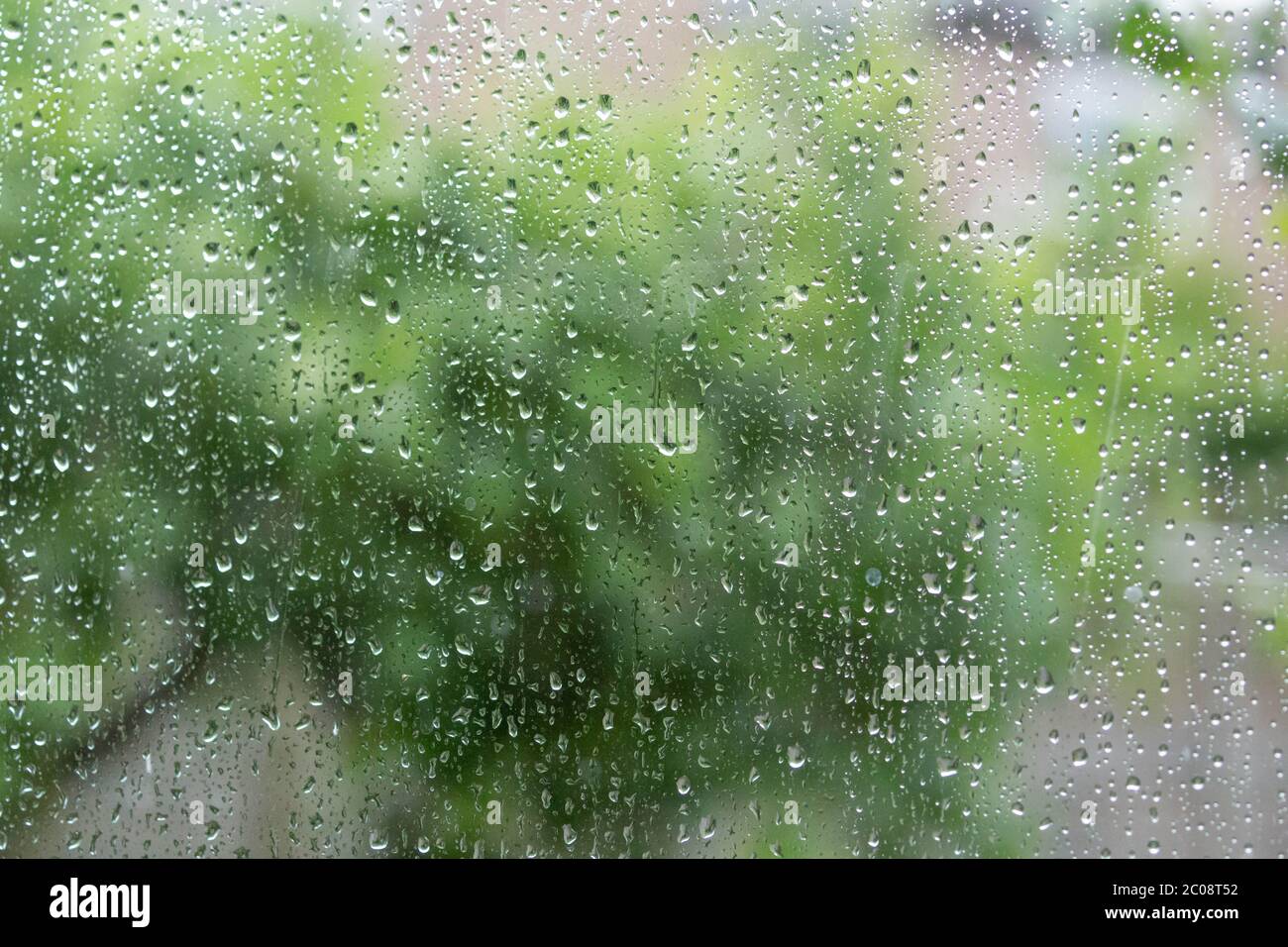 Gocce di pioggia su un pannello di finestra dall'interno di una casa. Foto Stock
