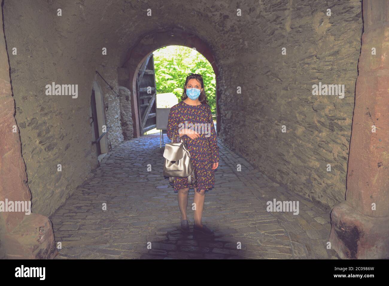 Donna in maschera medica viaggiatore visitare bella attrazione turistica godendo di una fortezza vagabondante, i turisti temono il virus 2019-ncov. Medico mascherato Foto Stock