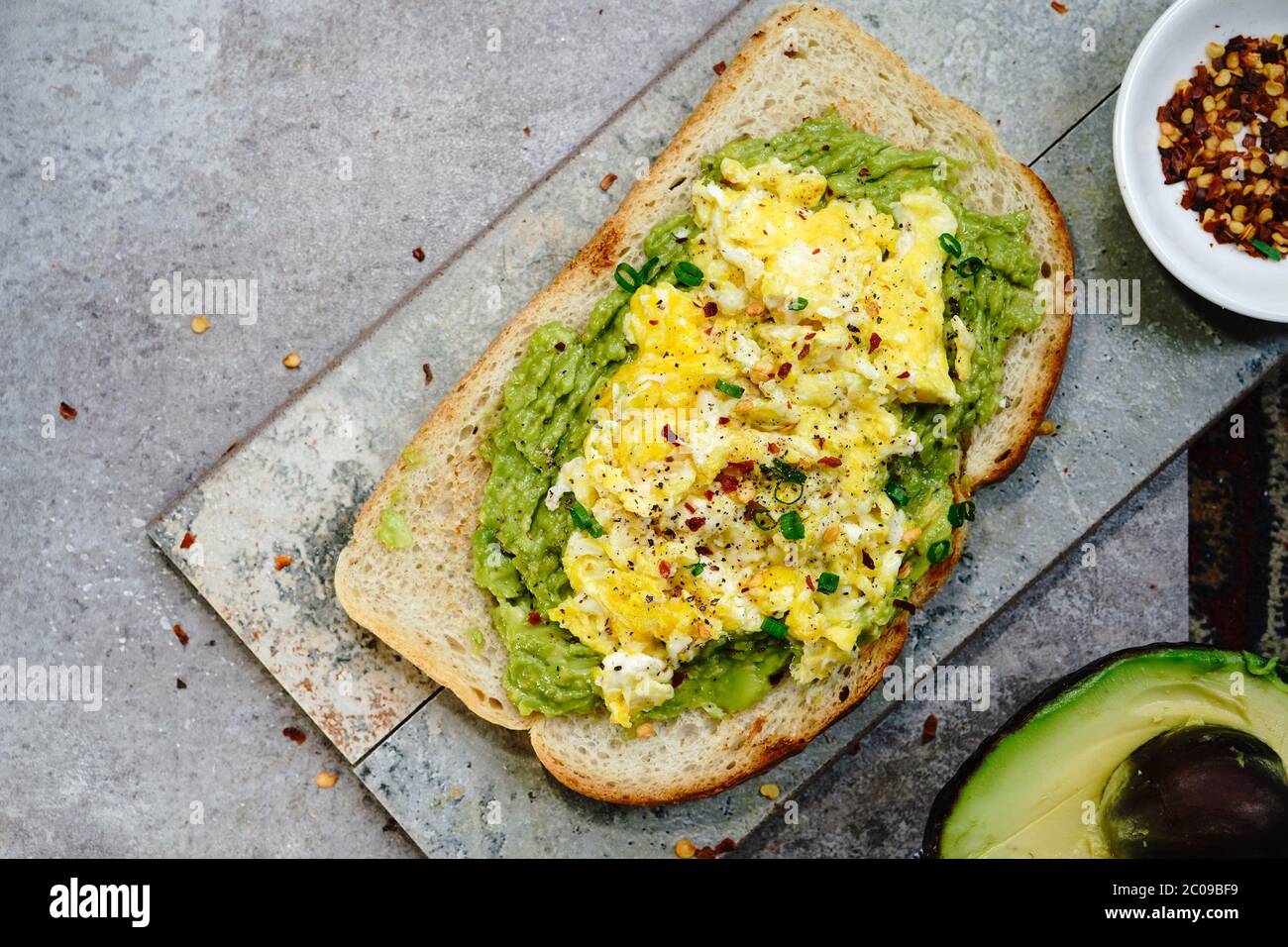 Toast all'avocado con uova strapazzate su pane di pasta acida, fuoco selettivo Foto Stock