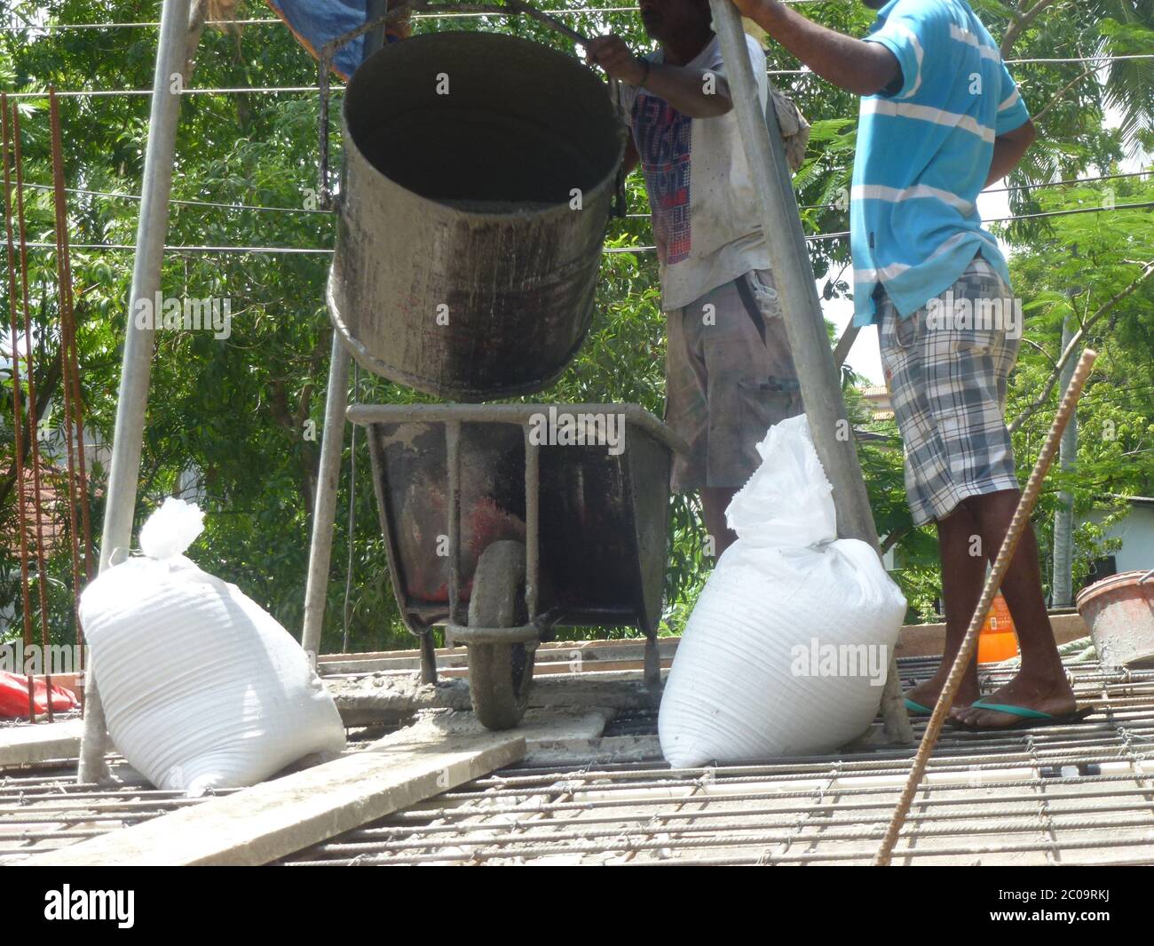 Uomini che lavorano in un cantiere coinvolto con Mason Work. Una nuova lastra di cemento è stata appena messa. Colombo, Sri Lanka. Foto Stock