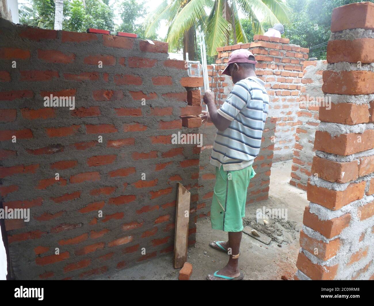 Uomini che lavorano su un cantiere, costruendo muri da mattoni. Colombo, Sri Lanka. Foto Stock