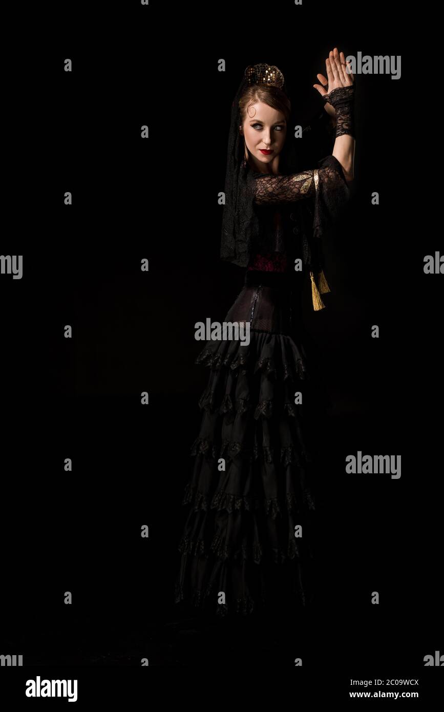 ballerina di flamenco giovane e attraente che danzano e che batte le mani isolate su nero Foto Stock