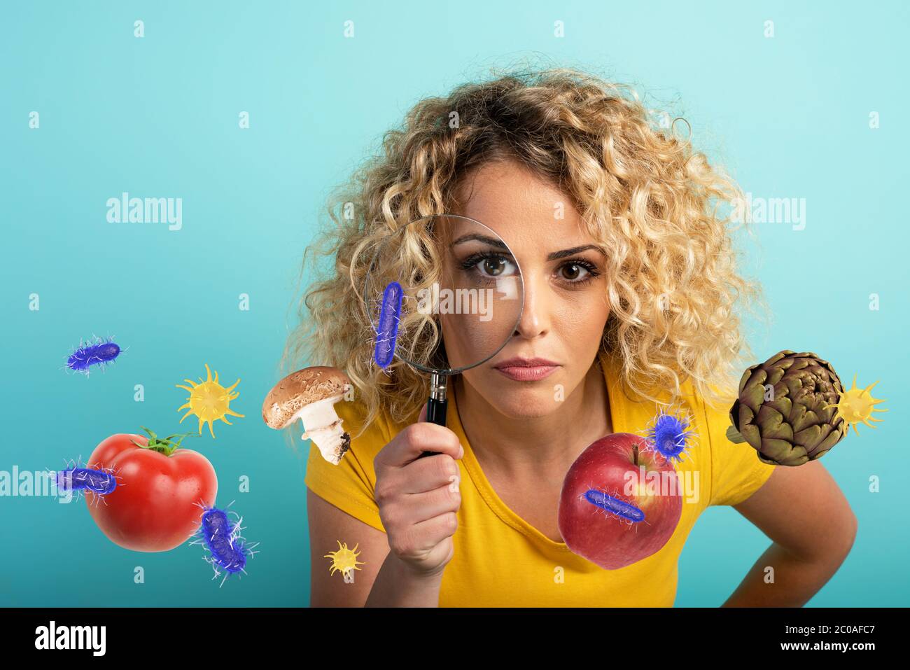 La ragazza è diffidente circa il contagio dei batteri sul cibo. Sfondo ciano Foto Stock