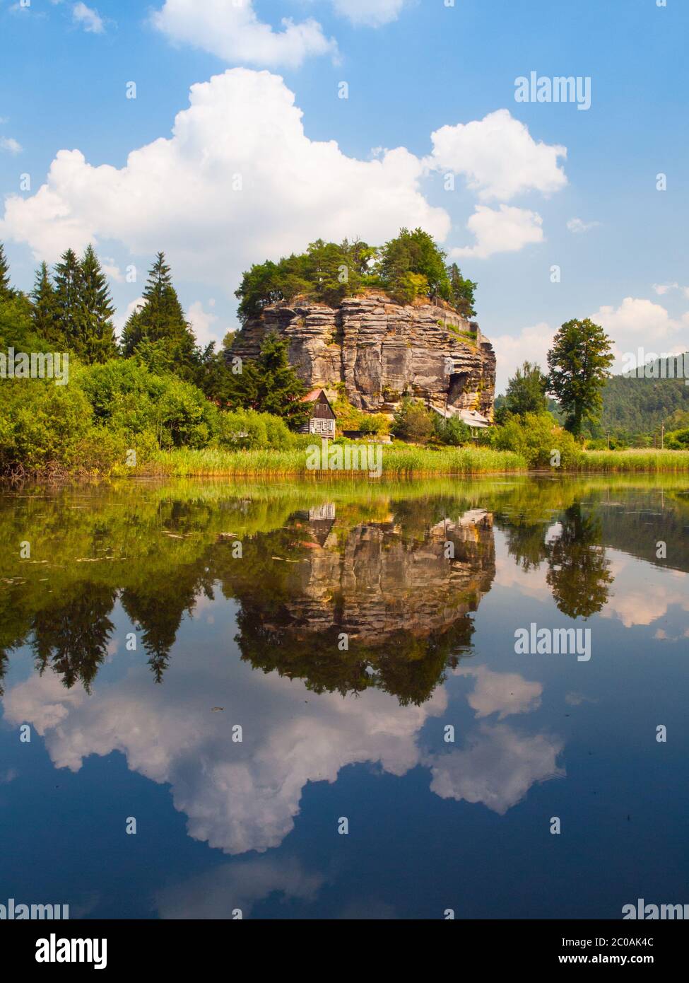 Castello di roccia Sloup v Cechach riflesso in acqua il giorno di sole, Boemia settentrionale, Repubblica Ceca Foto Stock