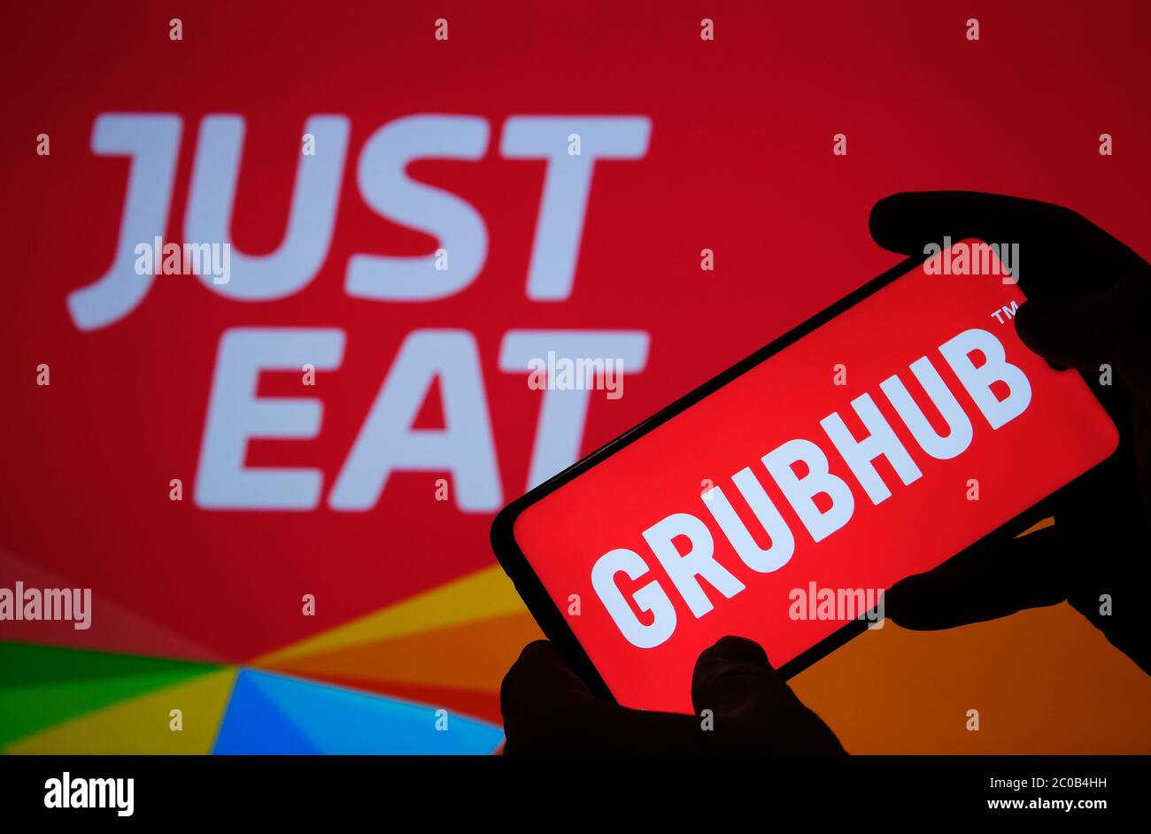 Stone / Regno Unito - Giugno 11 2020: Logo della società GRUBHUB visto sulla silhouette smartphone e SOLO MANGIARE il logo di consegna cibo sullo sfondo sfocato. C Foto Stock