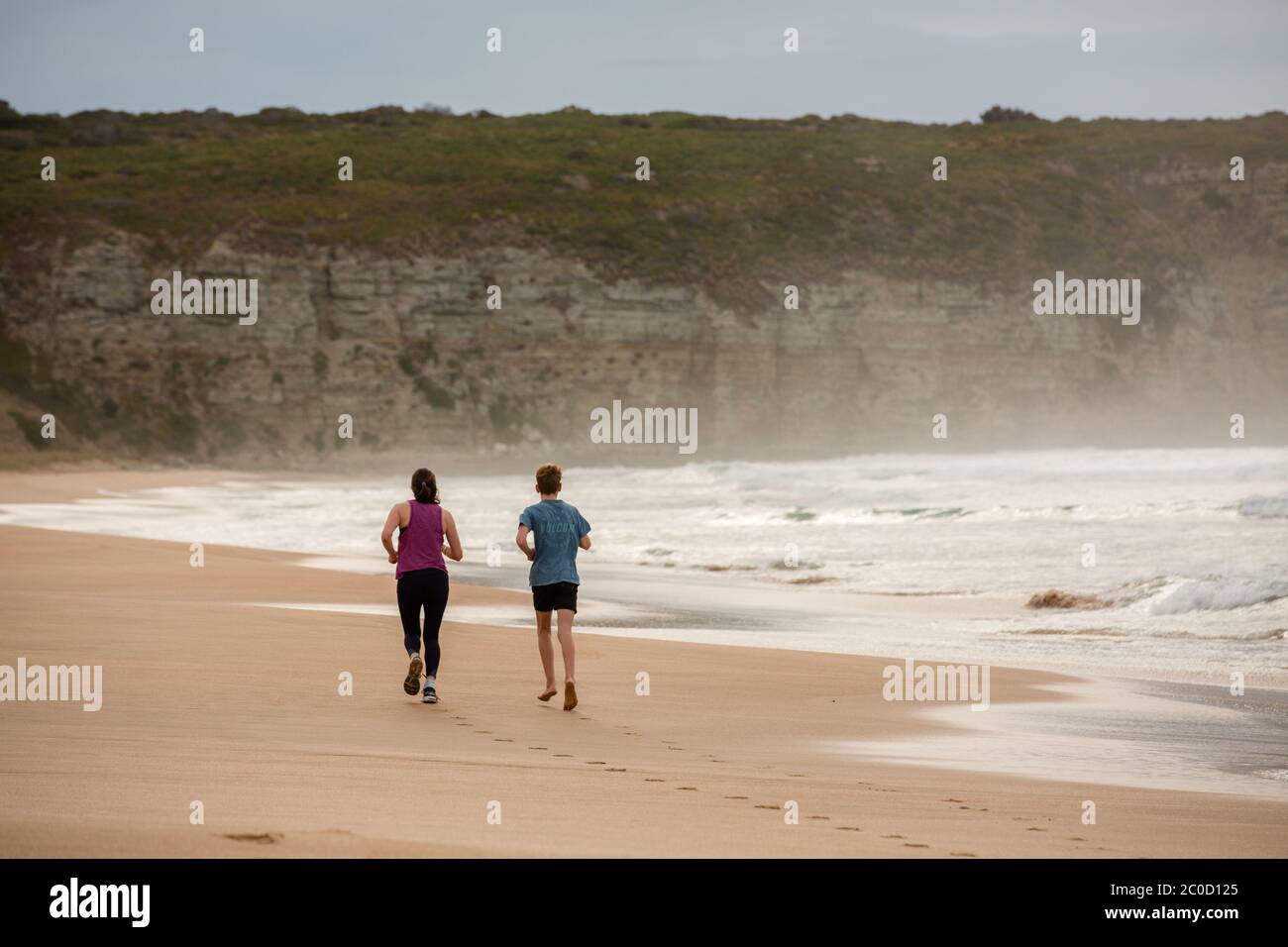 Uomo e donna che corrono a Clifton Beach South Arm Tasmania Australia Foto Stock