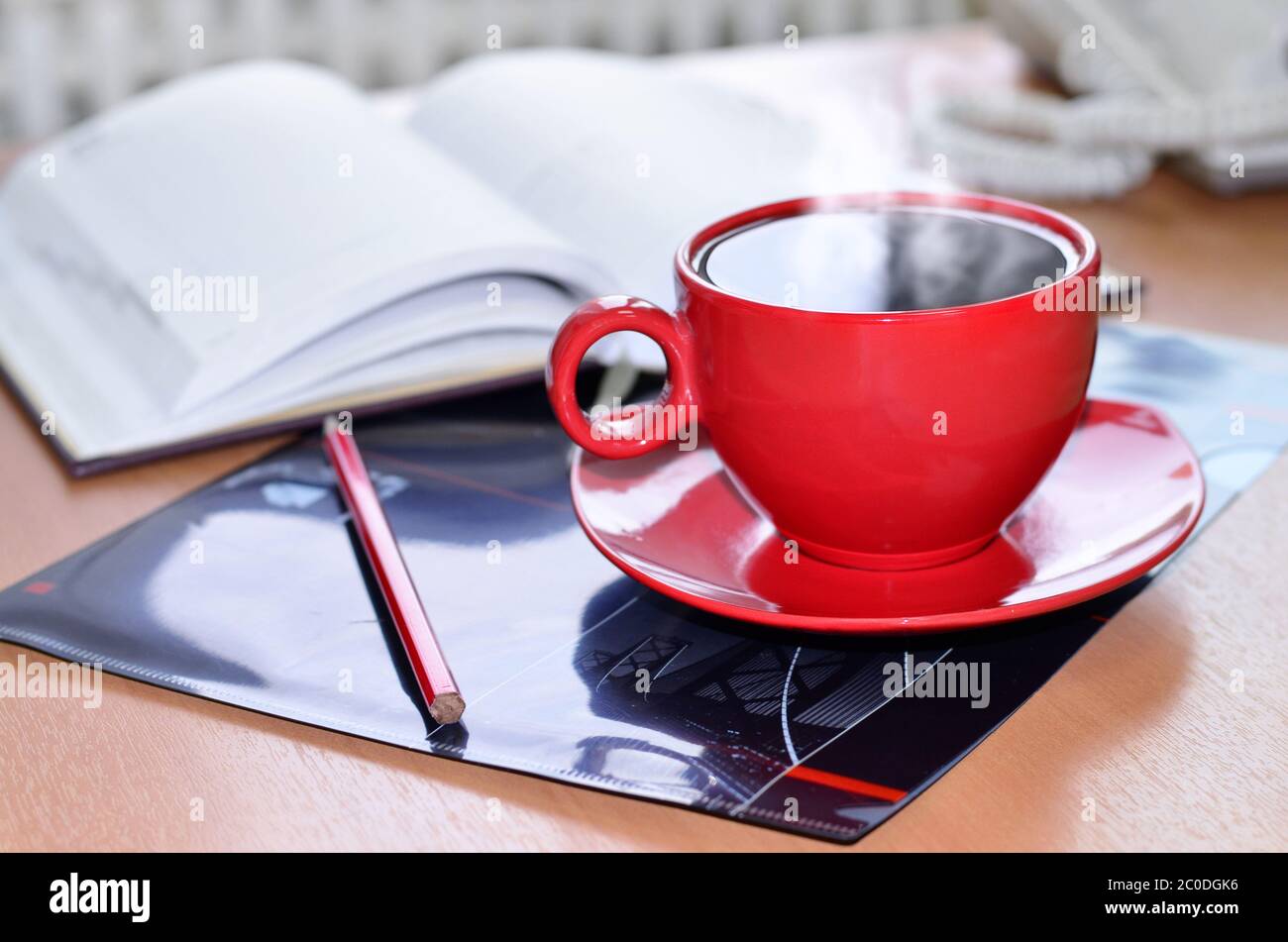 Una tazza di caffè rossa sulla scrivania in ufficio Foto Stock