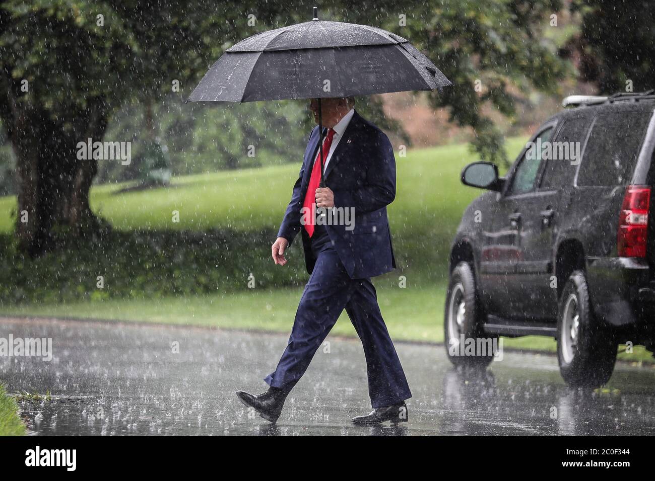 Il presidente degli Stati Uniti Donald J. Trump cammina sul prato sud della Casa Bianca in una pioggia pesante prima di salire a bordo di Marine One il 11 giugno 2020 a Washington, DC., per un viaggio a Dallas, Texas.Credit: Oliver Contreras/Pool via CNP /MediaPunch Foto Stock