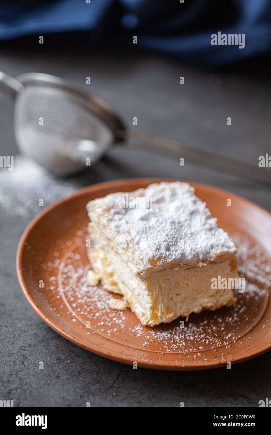 Cremșnit seduta sopra un piatto. È composto da pasta filata di solito tre strati con crema sopra e crumble spruzzato su di esso. Foto Stock