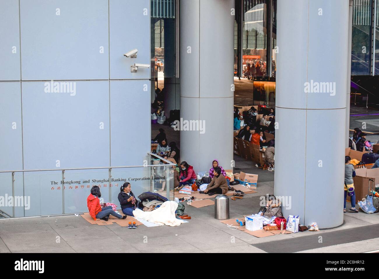 Gli immigrati poveri accamparono alle scatole di cartone di fronte alla società bancaria di Hong Kong e Shanghai all'isola di Hong Kong Foto Stock