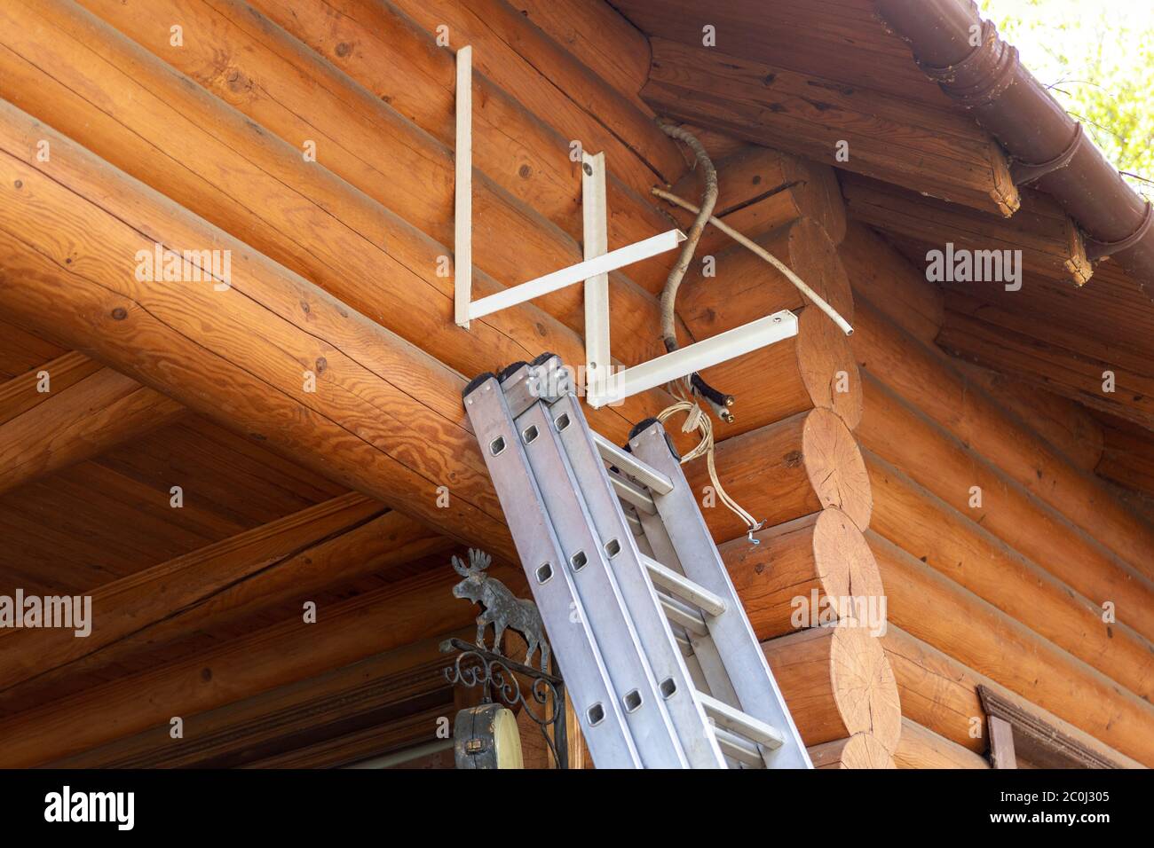 Nuovo impianto di climatizzazione esterno compressore montaggio a parete in metallo o processo di sostituzione su parete legno casa cottage residenziale Foto Stock