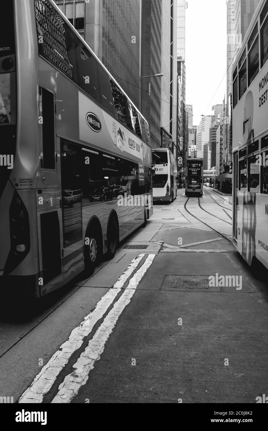Tram a due piani e autobus che guidano per le strade di Hong Kong Cina Foto Stock