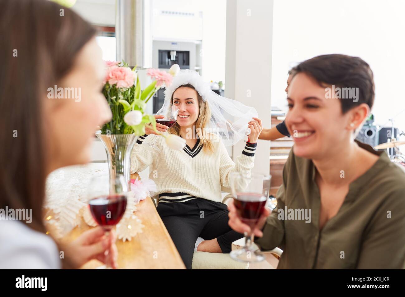 Le girlfriends ridenti celebrano la festa di gallina con la sposa prima del matrimonio con il vino rosso Foto Stock