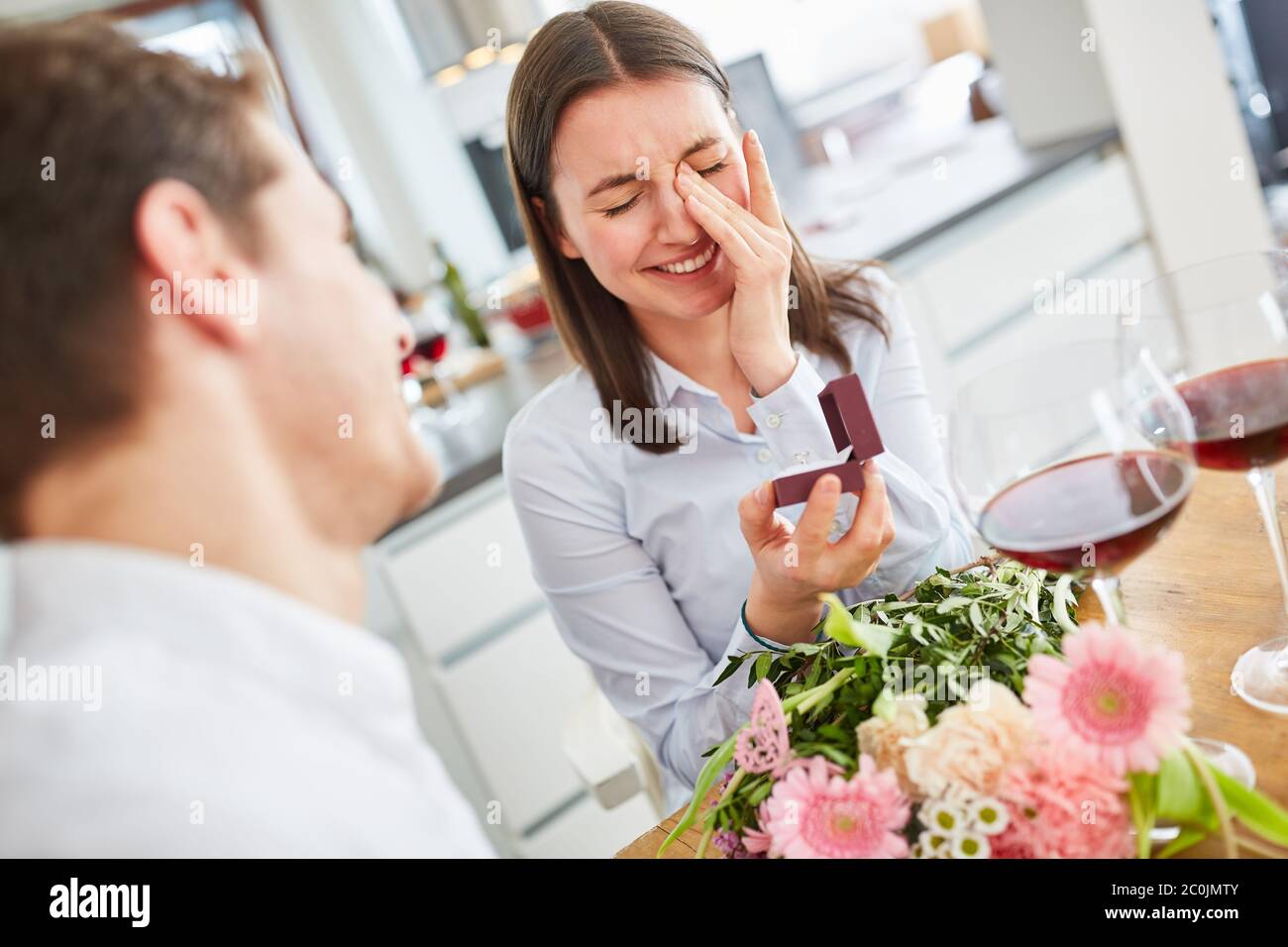Giovane donna felice con anello di nozze a proposta di matrimonio a casa strappare salviette per la gioia dagli occhi Foto Stock