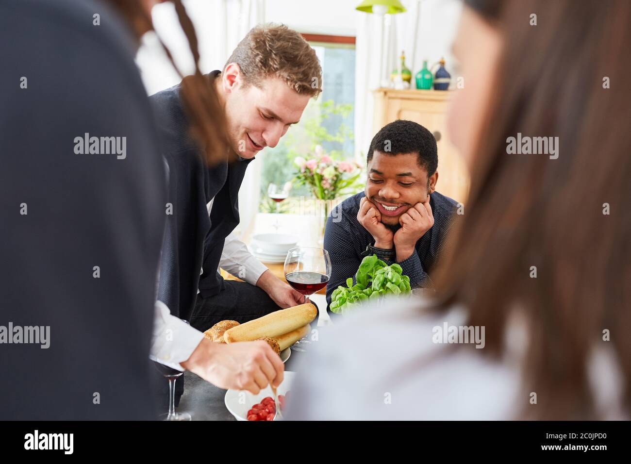 Amici felici insieme in cucina preparare il cibo per il pasto insieme Foto Stock