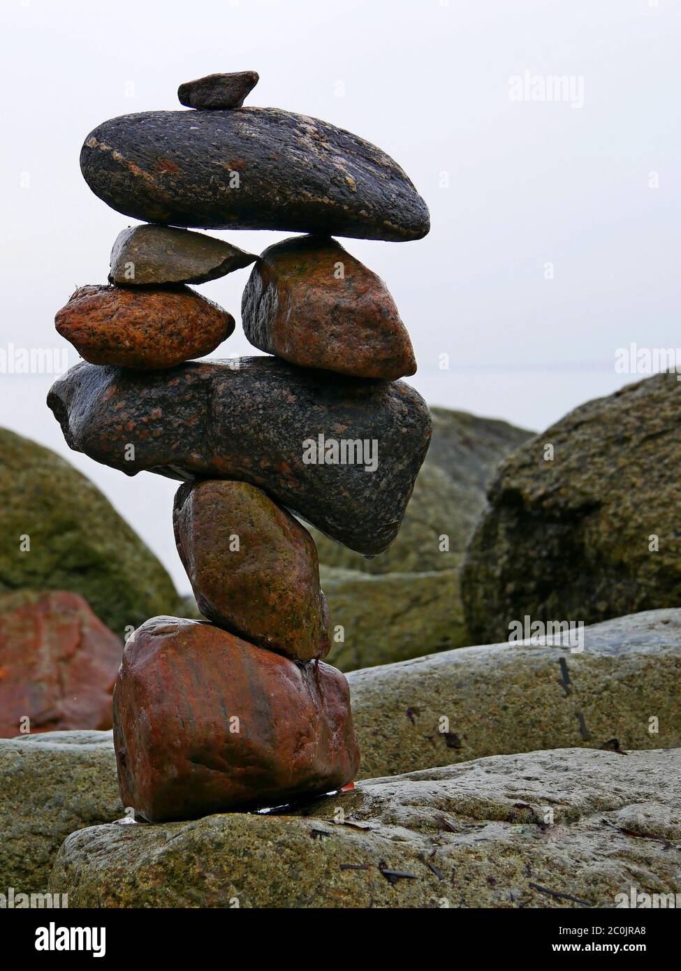 l'arte delle pietre equilibranti, accatastate su una grande pietra sulla spiaggia Foto Stock