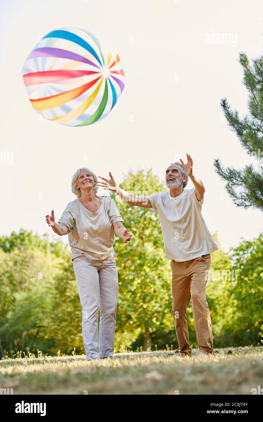 Coppia di anziani gioca con una palla colorata in estate in natura Foto Stock