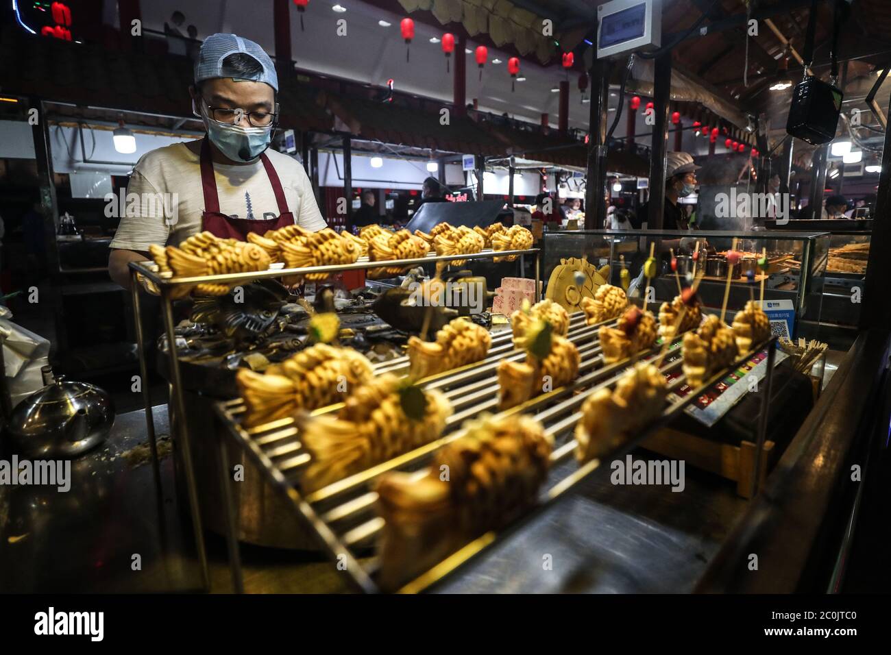 (200612) -- PECHINO, 12 giugno 2020 (Xinhua) -- UN venditore prepara il cibo al mercato notturno internazionale di Tawan Xingshun a Shenyang, nella provincia di Liaoning della Cina nordorientale, 7 giugno 2020. (Xinhua/Pan Yulong) Foto Stock