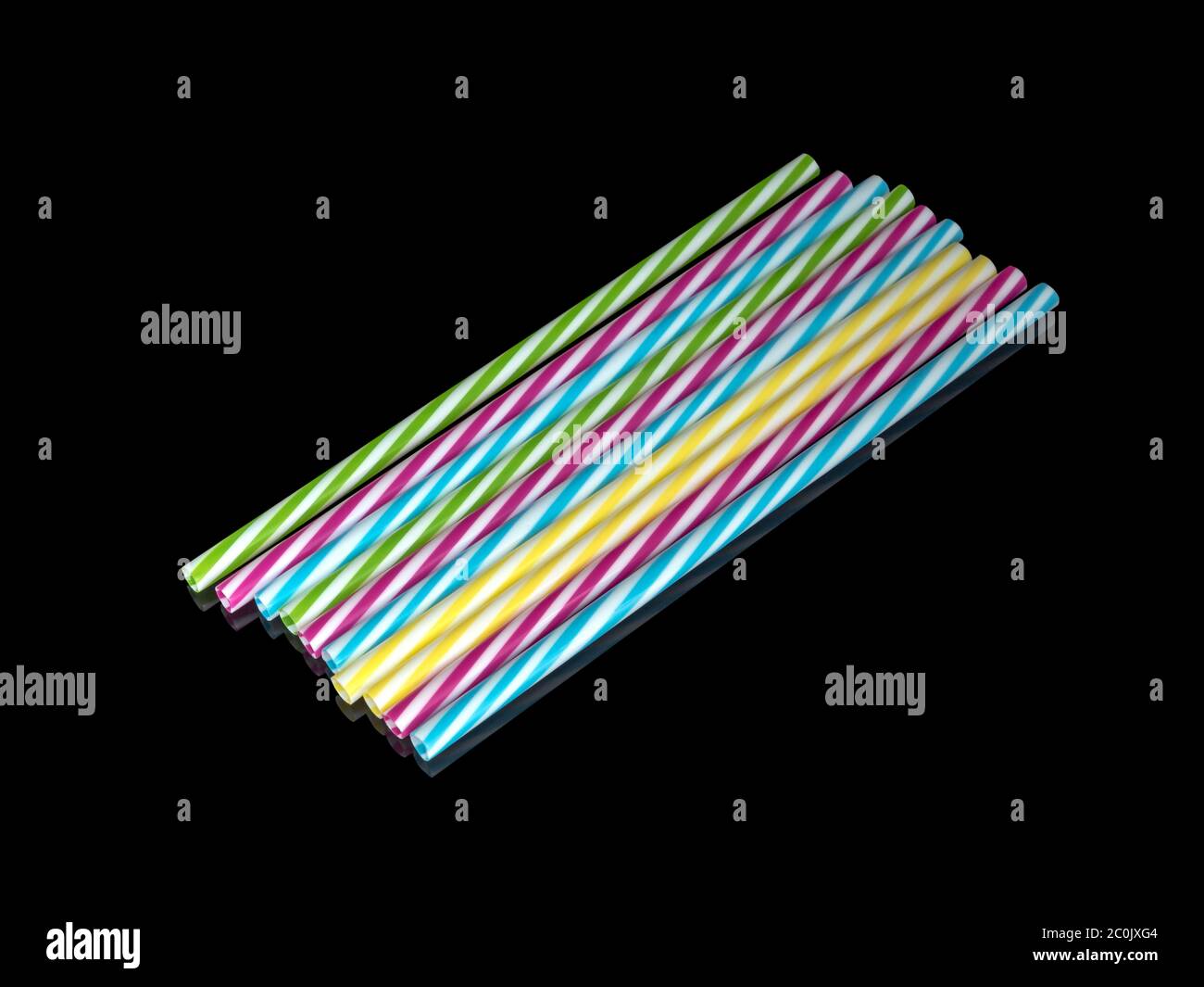 Pile di colorate paglia potabile in plastica a righe, sottoterra nera Foto Stock