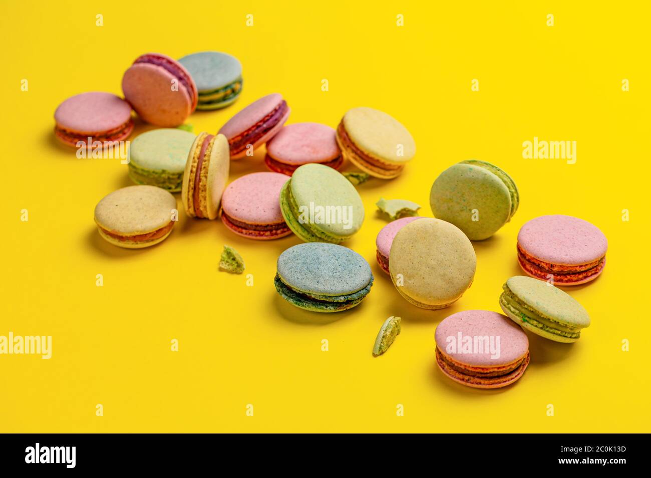 Macaroni francesi dolci e colorati su sfondo giallo Foto Stock