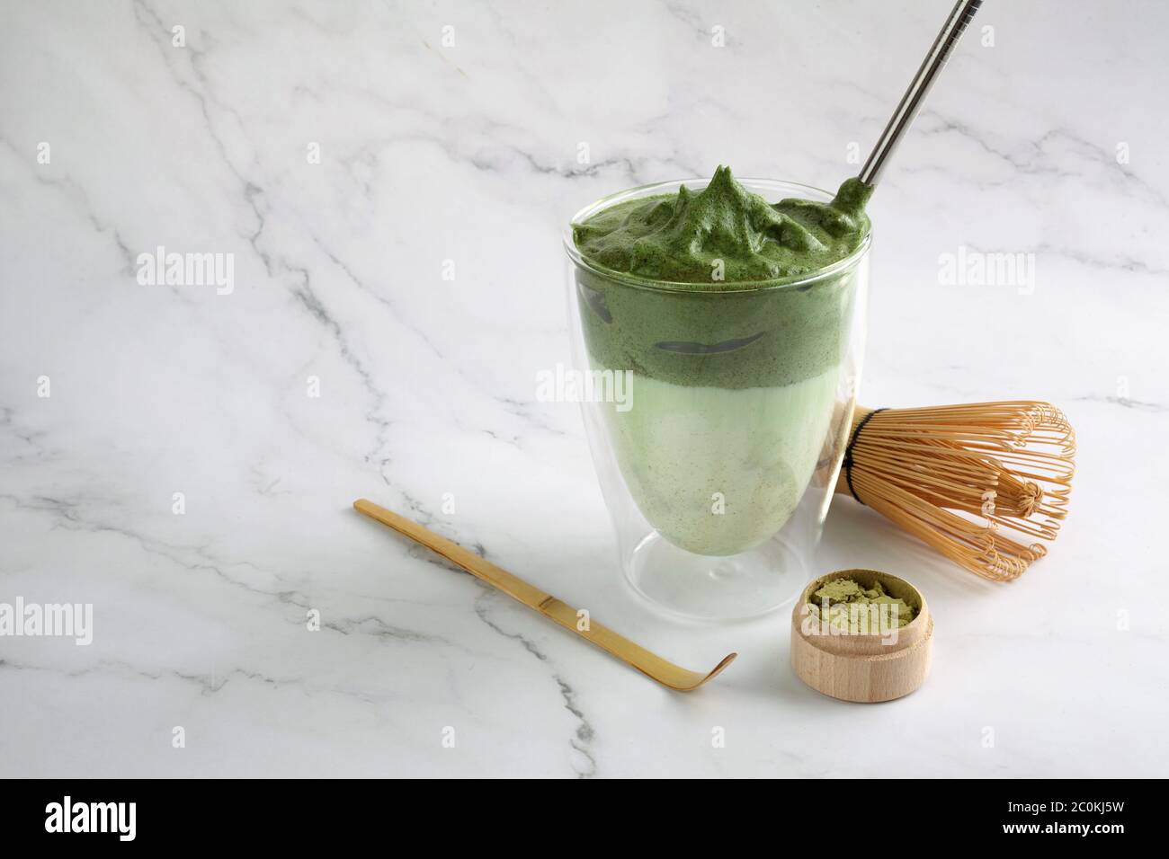 Dalgona matcha verde. Drink hipster alla moda su sfondo di marmo. Foto Stock