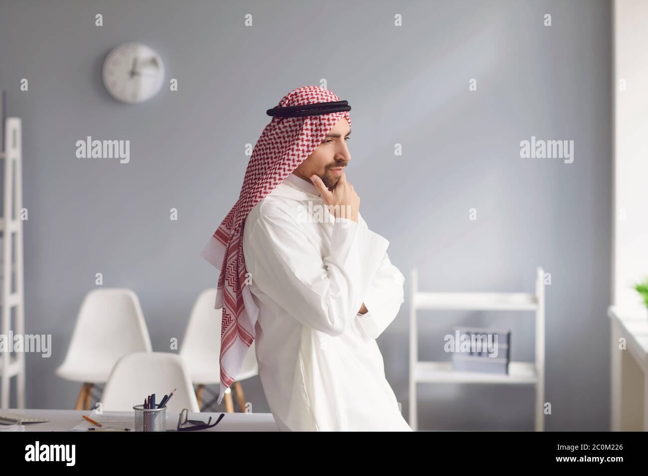 L'uomo arabo serio pensivo guarda in un ufficio bianco Foto Stock
