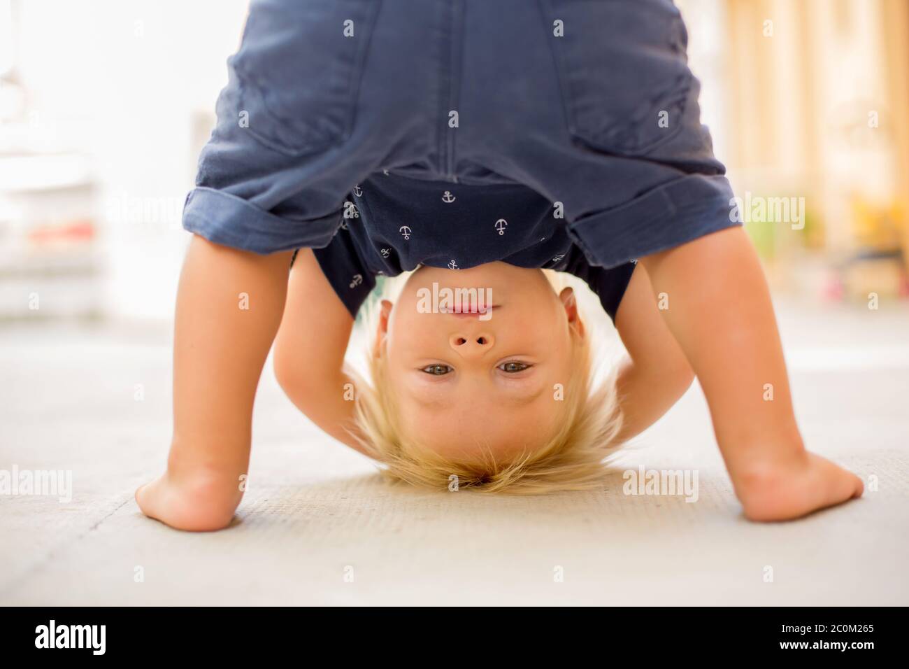 Bambino in piedi capovolto, sorridendo felice mentre si divertono Foto Stock Bambino in piedi capovolto, sorridendo felice mentre si divertono Foto Stock